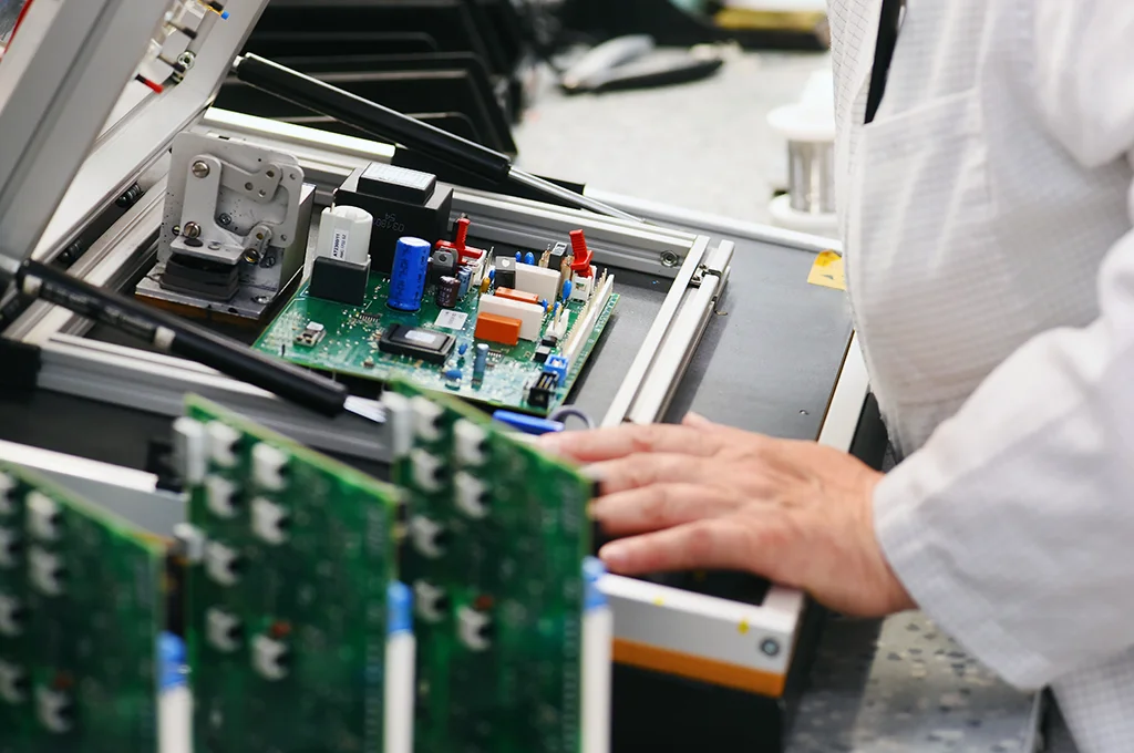 5 engineer testing assembled pcb prototype in lab